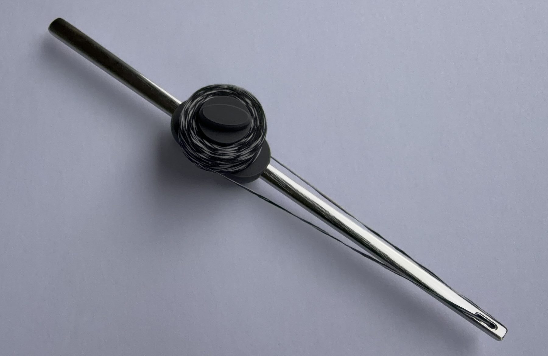 Flosser Wand threaded with floss, seen at an angle