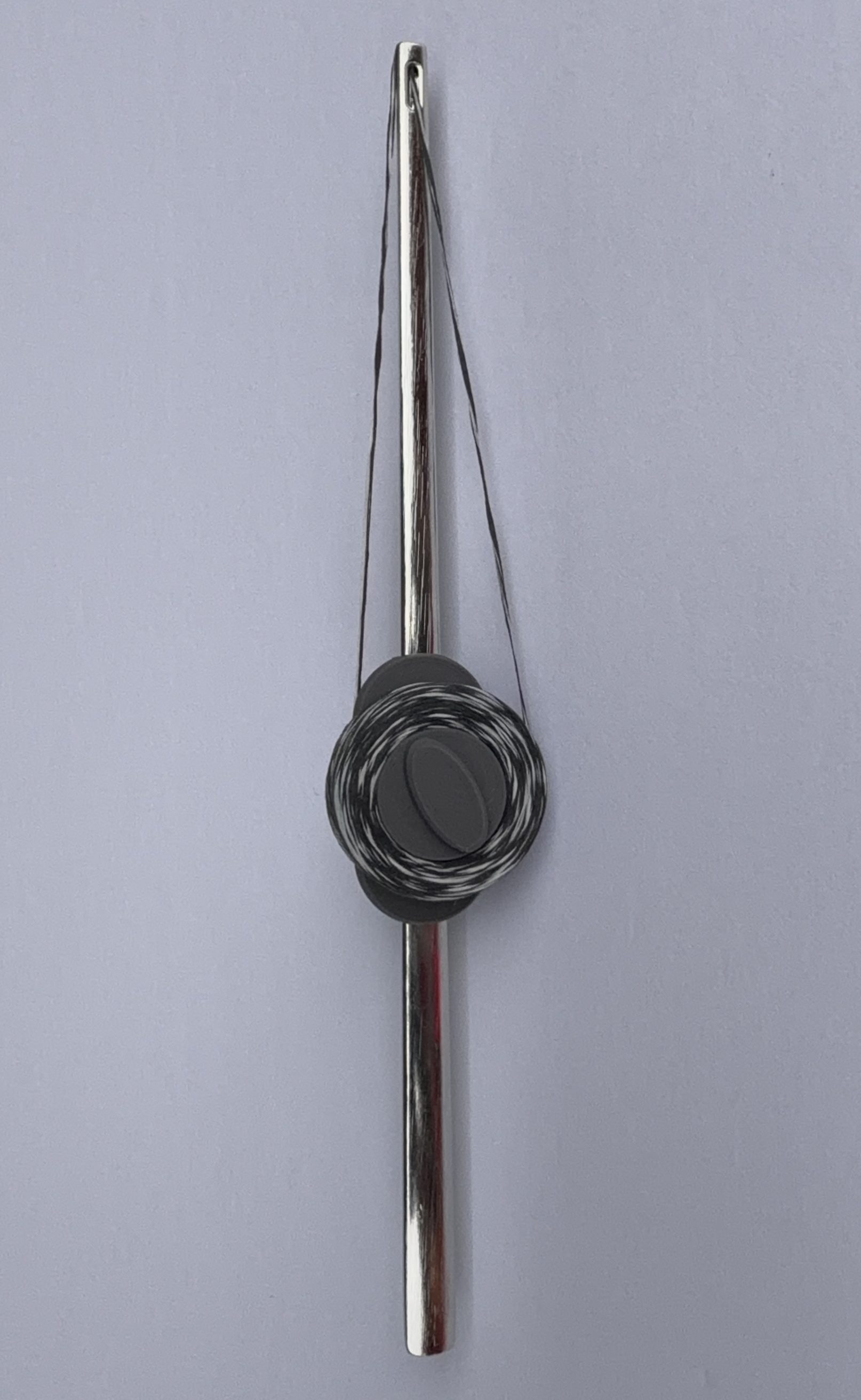 Flosser Wand upright with floss threaded through the eye