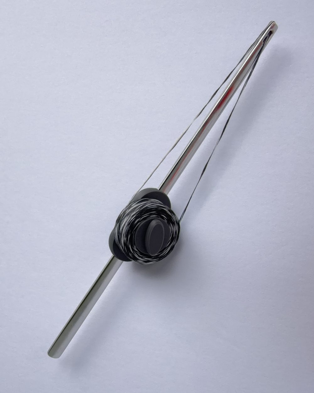 Flosser Wand from the side, floss threaded and taut