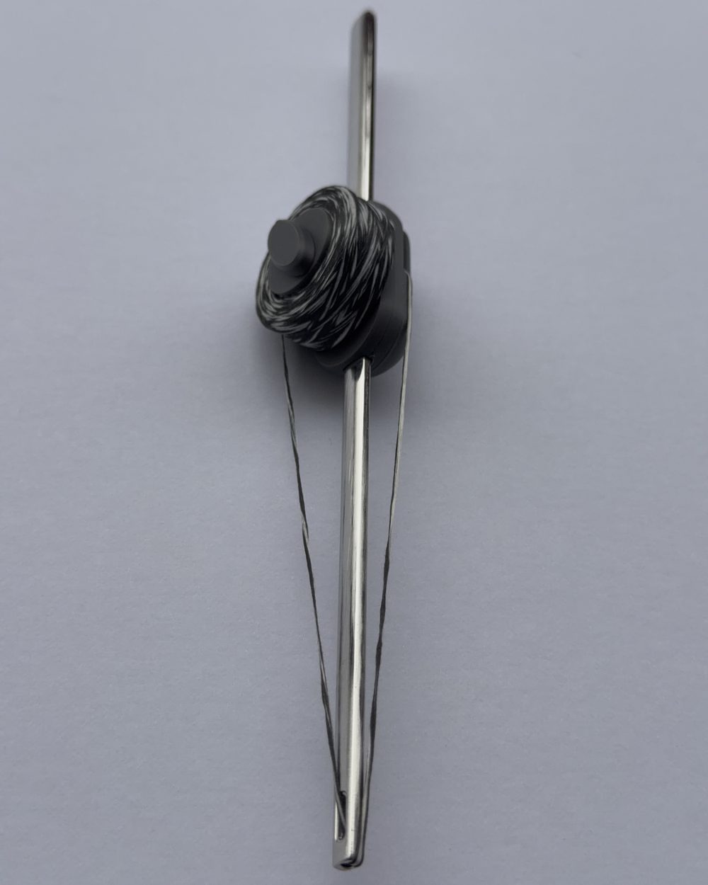 Flosser Wand upright, floss threaded and drawn taut